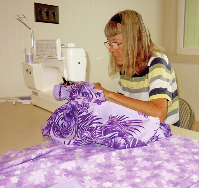 4045576_web1_Kathleen-Callicrate-is-one-of-eight-volunteers-sewing-dresses-in-Waikoloa-s-Community-Room-on-Wednesday201682414819308.jpg