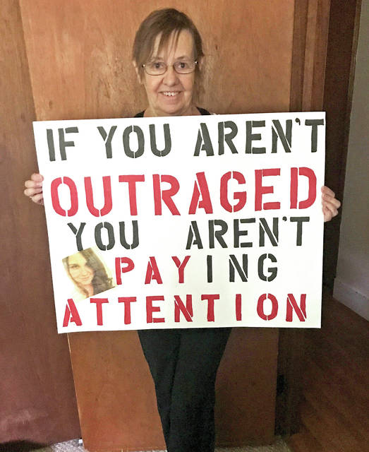 5824207_web1_Resident-holds-a-sign-she-uses-at-last-Friday-s-event2017822121735135.jpg