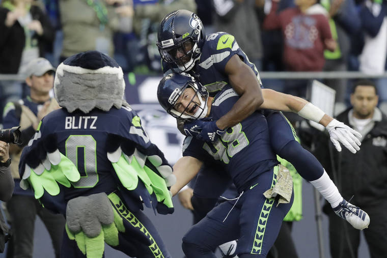 Seattle Seahawks quarterback Russell Wilson (3) greets tight end Jacob  Hollister, center, after Wilson passed to Hollister for touchdown against  the Tampa Bay Buccaneers during the first half of an NFL football