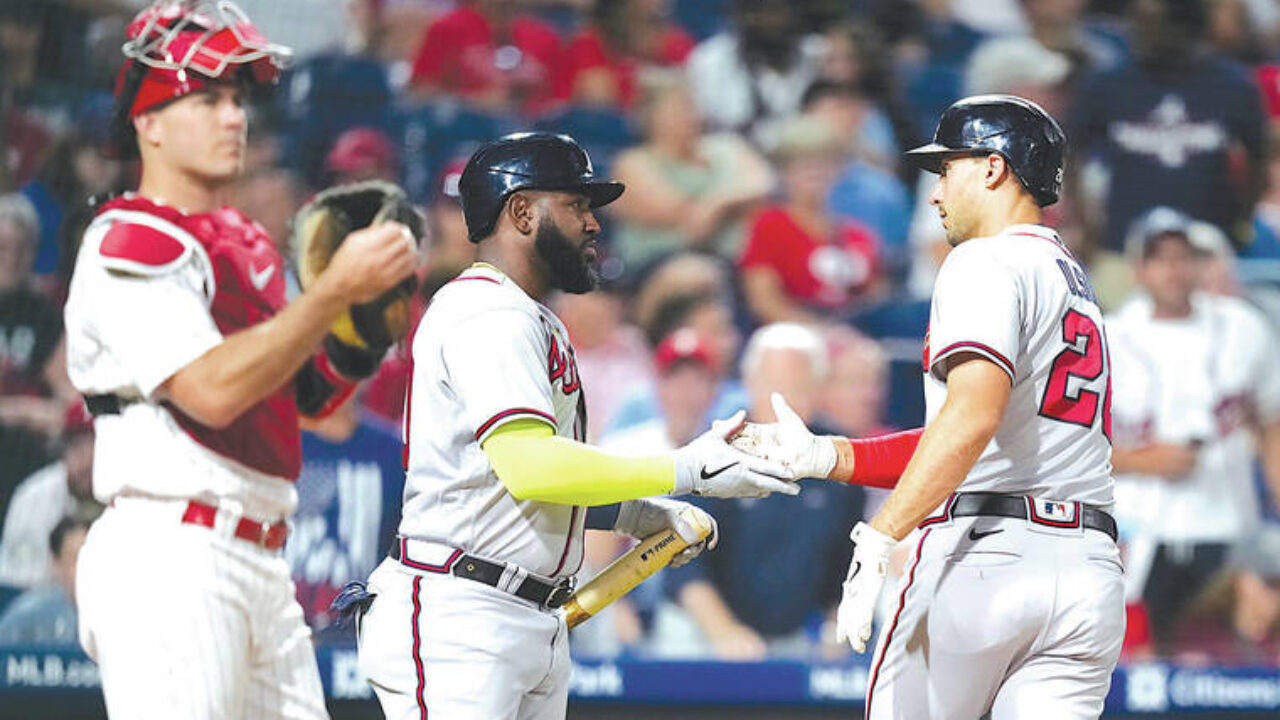 Philadelphia Phillies' Bryce Harper (3) high fives Trea Turner, right,  after scoring on an RBI-single hit by Bryson Stott during the third inning  of a baseball game against the Los Angeles Dodgers